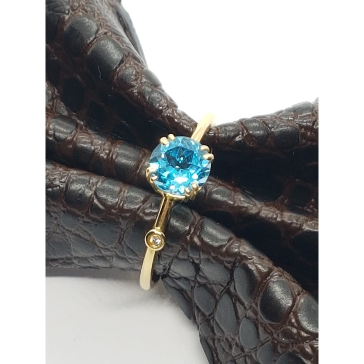 Anillo de oro amarillo con diamante y topacio azul